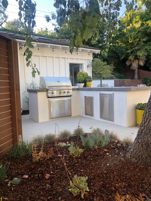 White farmhouse-style outdoor kitchen with concrete counters