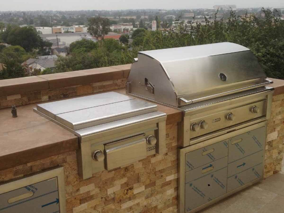 Quartzite-faced BBQ island with stainless grill and vent hood overlooking the South Bay