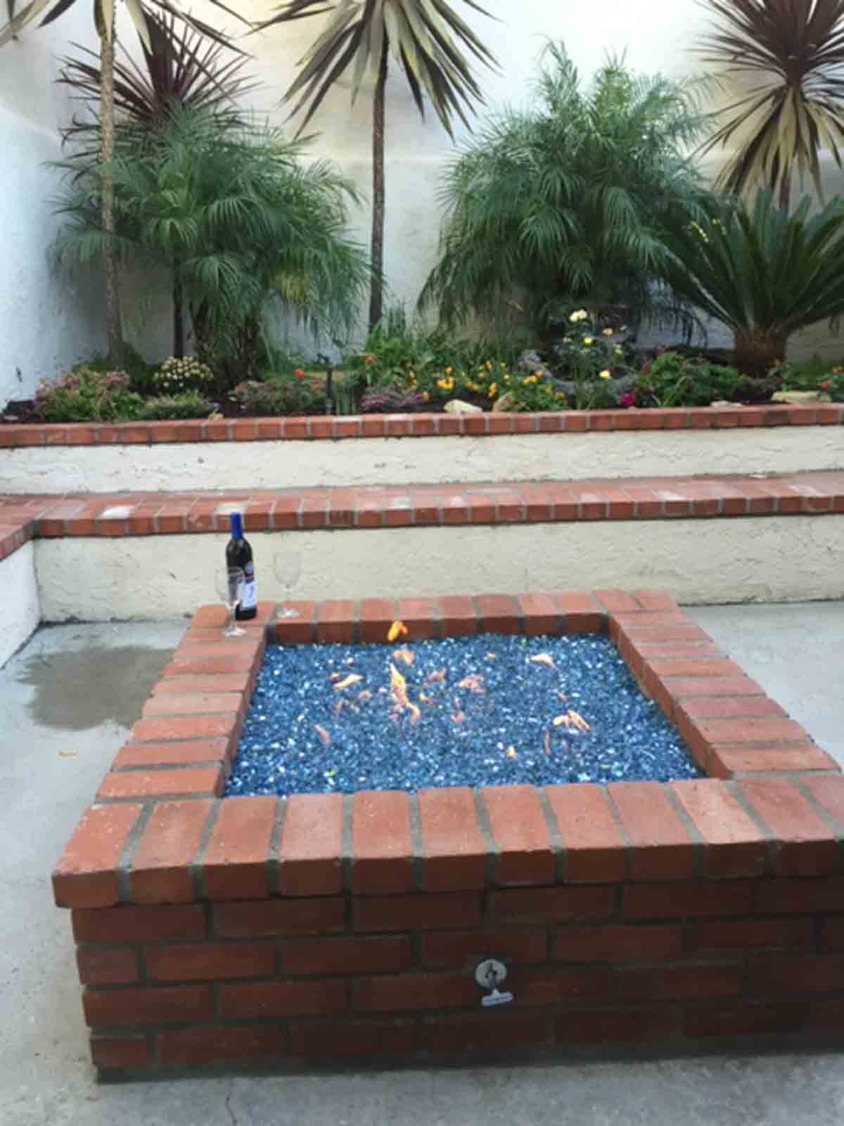 Square brick fire pit in a palm courtyard