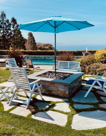 Fire pit with lounge chairs, pool, and ocean view