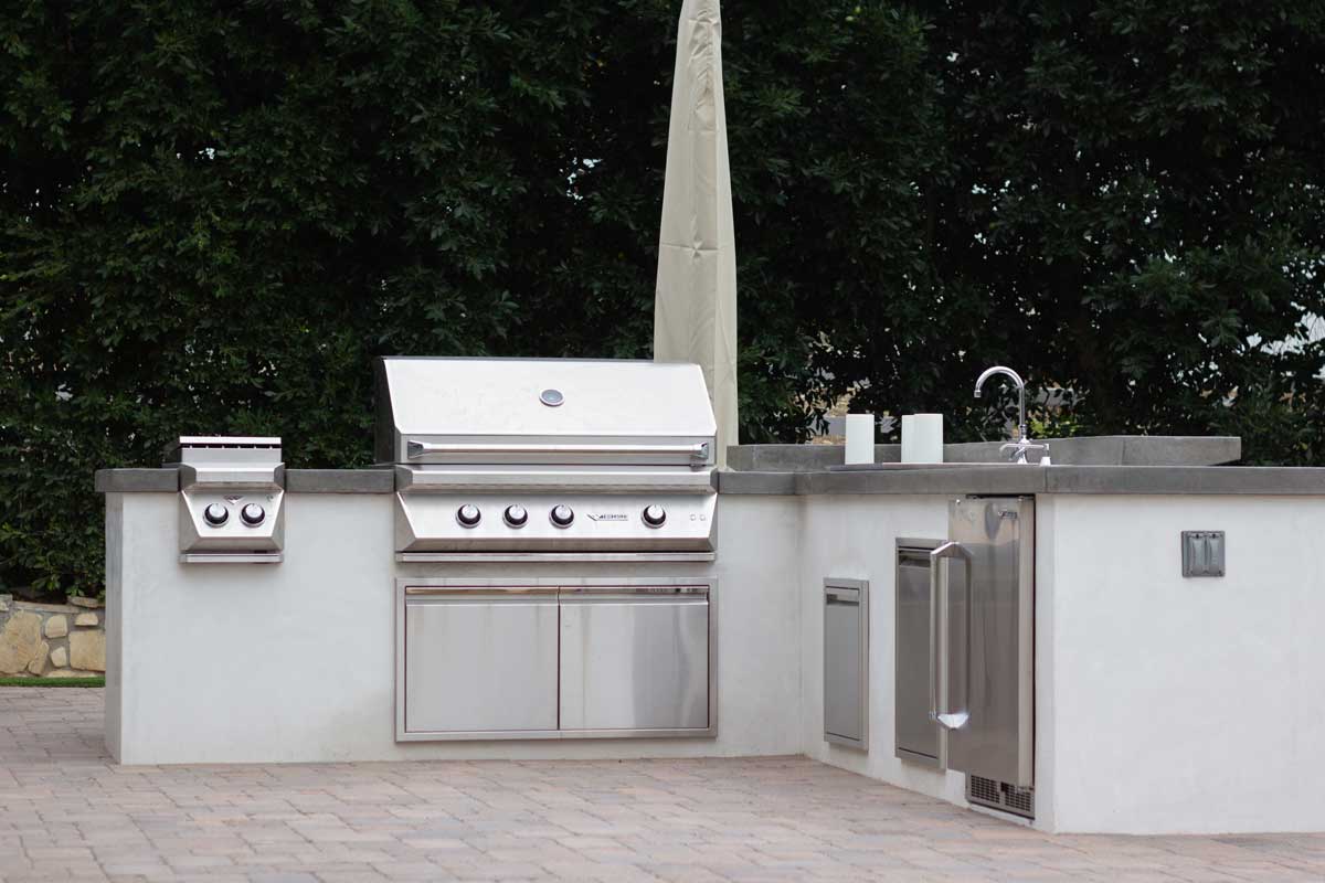 Custom outdoor kitchen with stone barbecue island