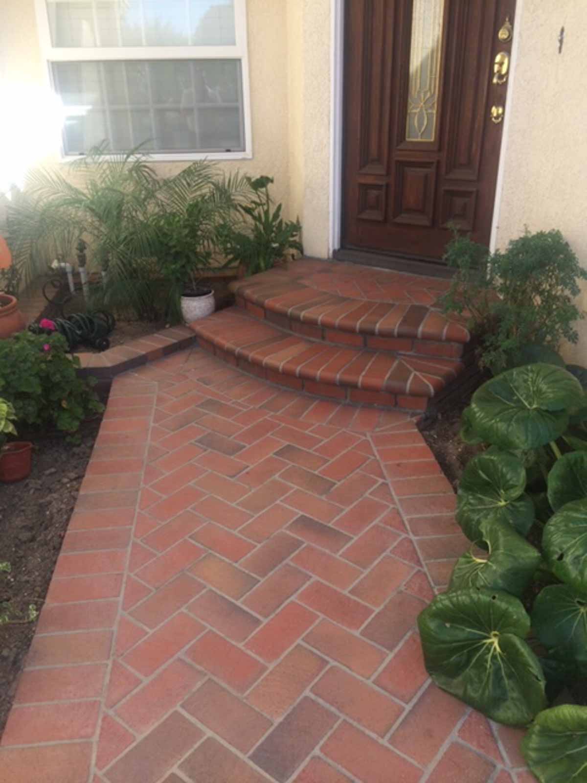 Herringbone brick walkway with rounded brick steps at a front entry