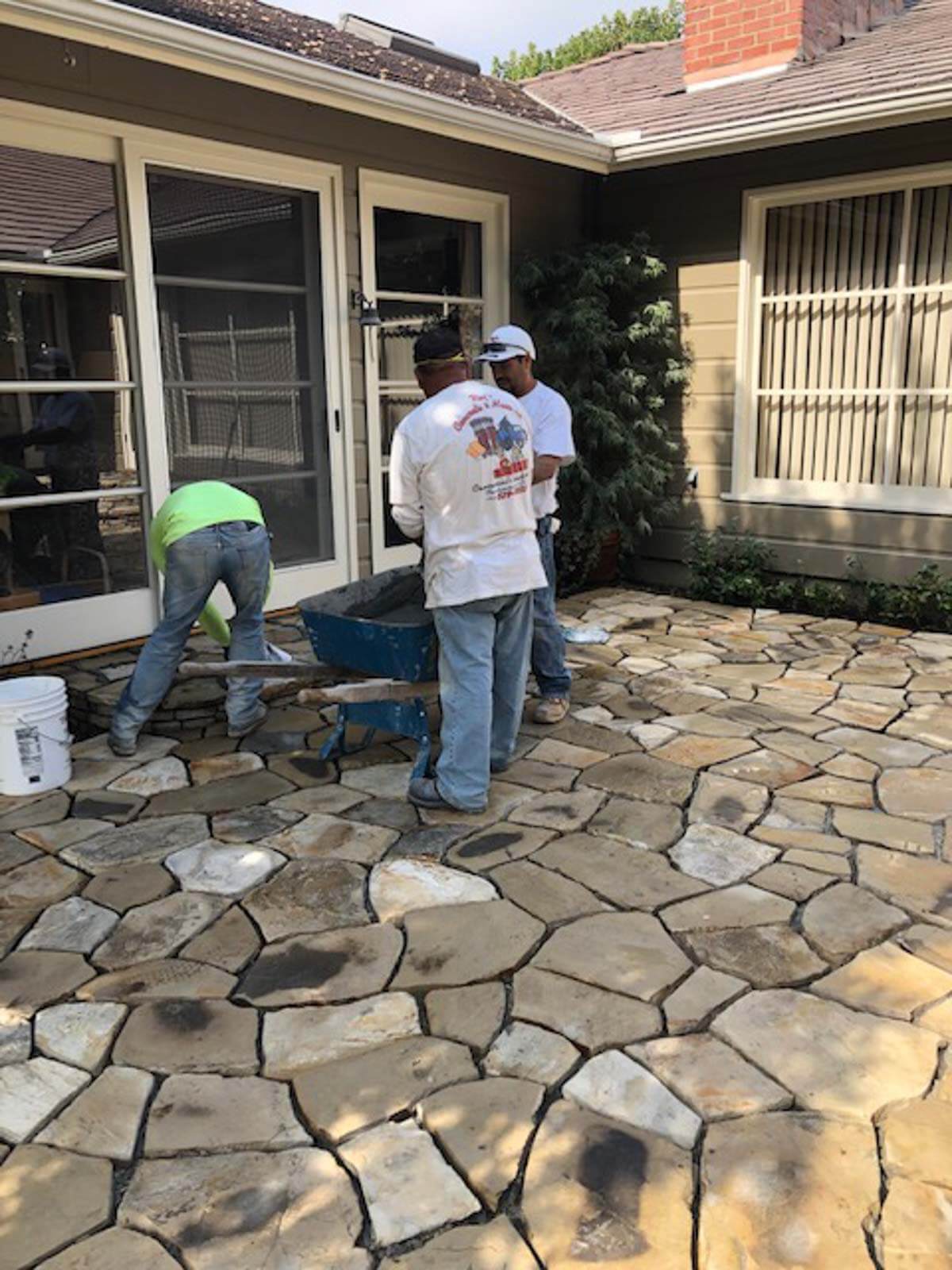 Roy's crew hand-fitting Lompoc stone pieces on a courtyard patio