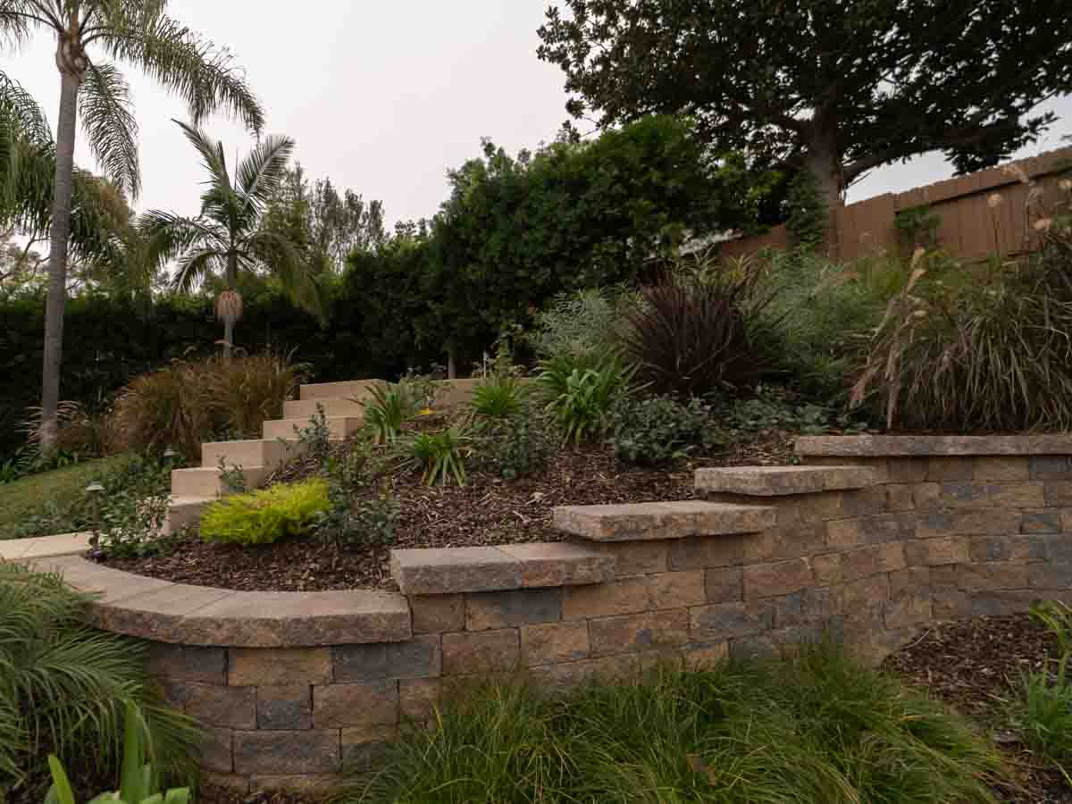 Terraced stone retaining walls on a hillside yard