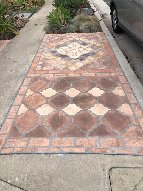 Walkway of arabesque terracotta pavers framed with a brick border