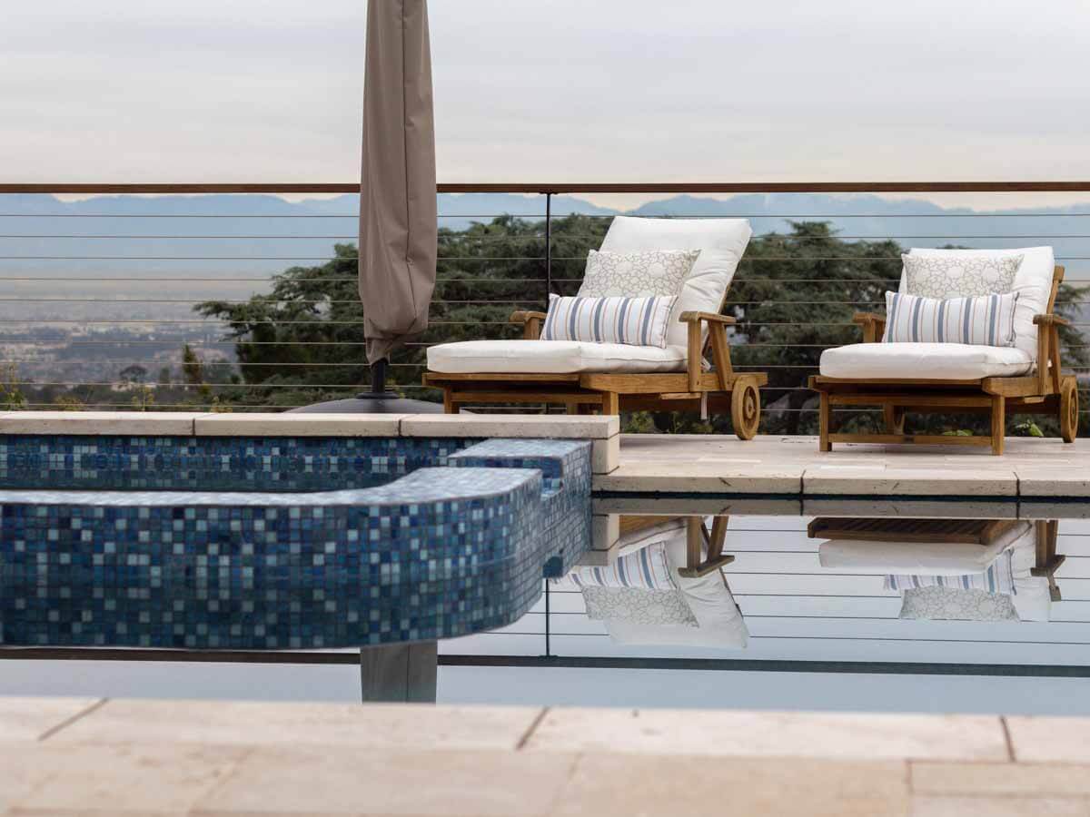 Blue mosaic tile spa in front of cushioned loungers overlooking the South Bay