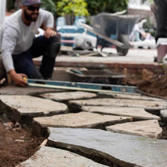 Roy's crew member laying a flagstone walkway